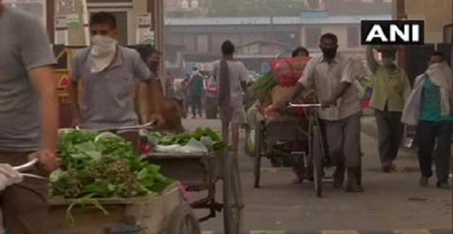 दिल्ली में कोरोना वायरस महामारी के बीच गाजीपूर फल और सब्जी मंडी से खरीदारी करने आए ग्राहक